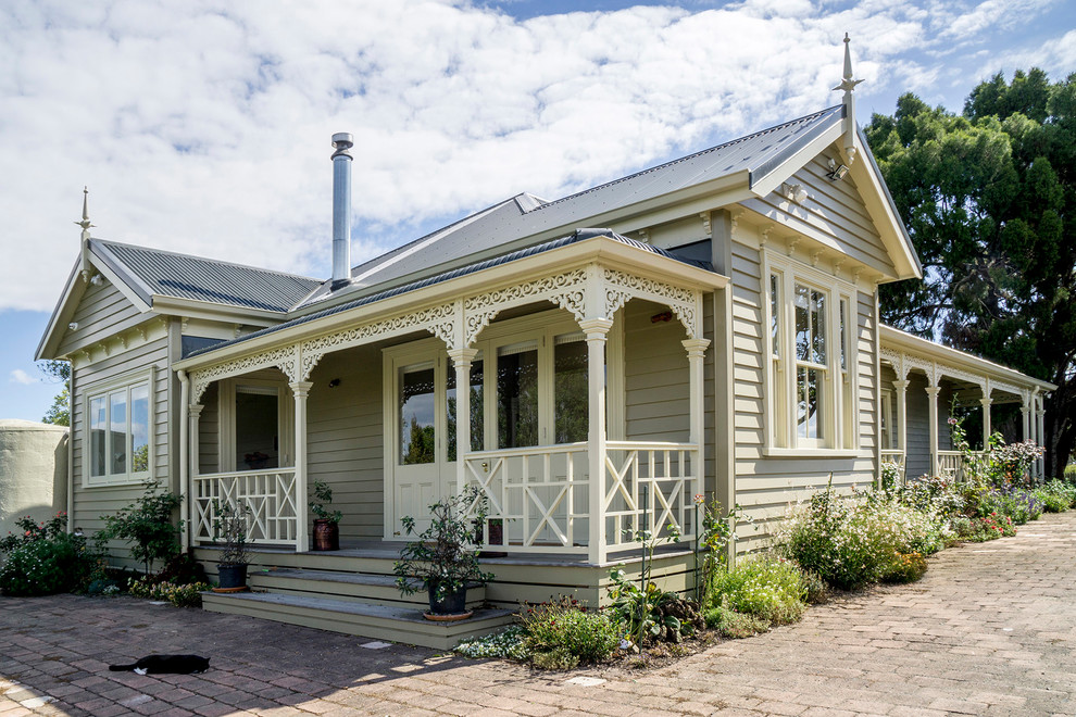 Einstöckiges Klassisches Einfamilienhaus mit grauer Fassadenfarbe, Satteldach und Blechdach in Auckland