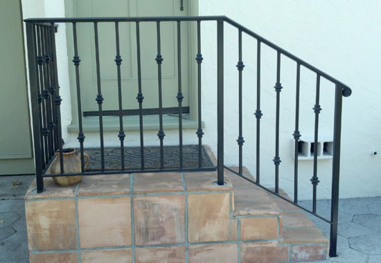 Imagen de escalera minimalista de tamaño medio con escalones con baldosas, contrahuellas con baldosas y/o azulejos y barandilla de metal