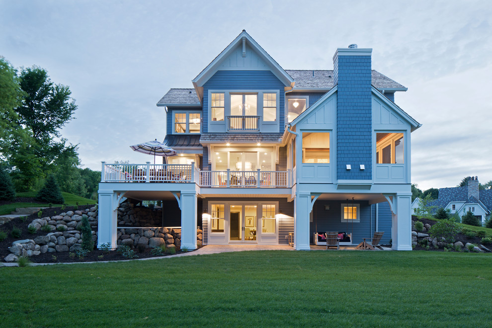 Réalisation d'une très grande façade de maison bleue tradition en panneau de béton fibré à un étage avec un toit à deux pans.