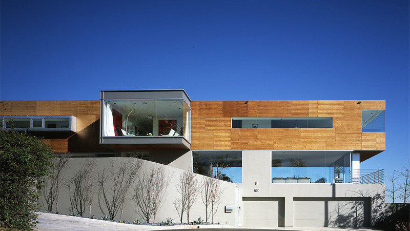 Réalisation d'une très grande façade de maison grise minimaliste en bois à niveaux décalés avec un toit plat.
