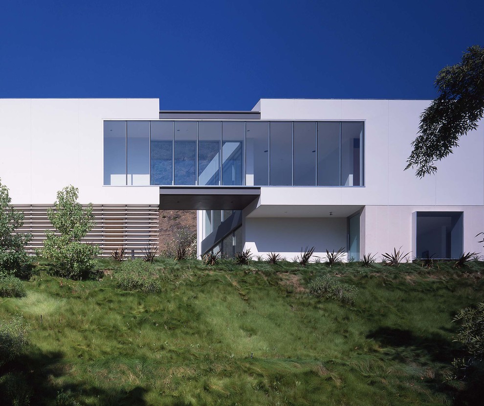 Idée de décoration pour une très grande façade de maison blanche design en béton à un étage avec un toit plat.