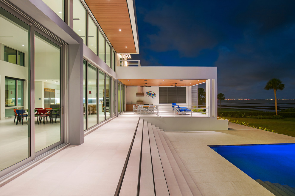 Large and white modern detached house in Tampa with three floors, mixed cladding, a flat roof and a green roof.