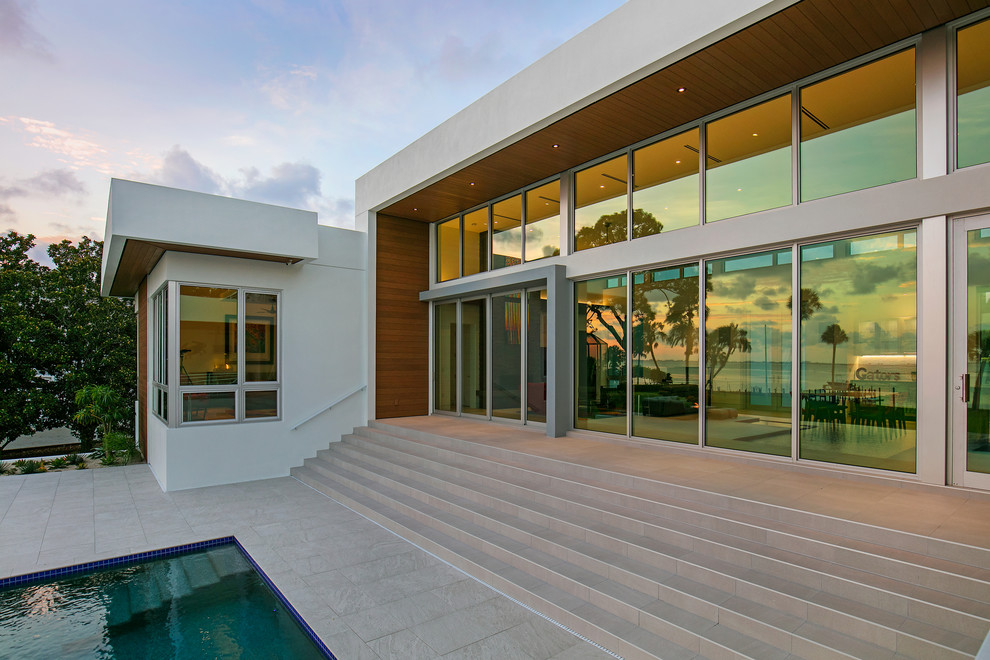 Diseño de fachada de casa blanca minimalista grande de tres plantas con revestimientos combinados, tejado plano y techo verde