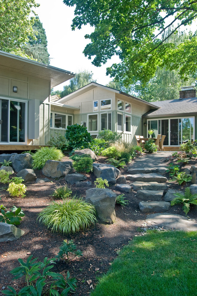 Photo of a medium sized and green retro bungalow house exterior in Portland with wood cladding and a lean-to roof.