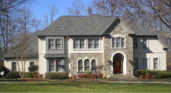 Medium sized and gey traditional two floor house exterior in Raleigh with stone cladding and a half-hip roof.
