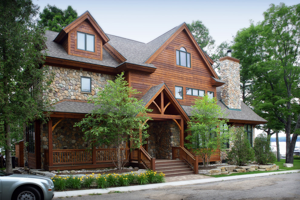 Ejemplo de fachada marrón tradicional grande de tres plantas con revestimiento de madera y tejado a dos aguas