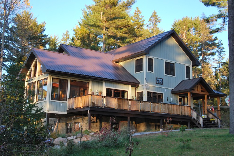 Idee per la facciata di una casa verde rustica a due piani di medie dimensioni con rivestimento in legno e tetto a capanna