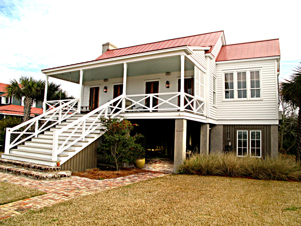 Aménagement d'une grande façade de maison blanche classique en bois à un étage avec un toit à croupette.