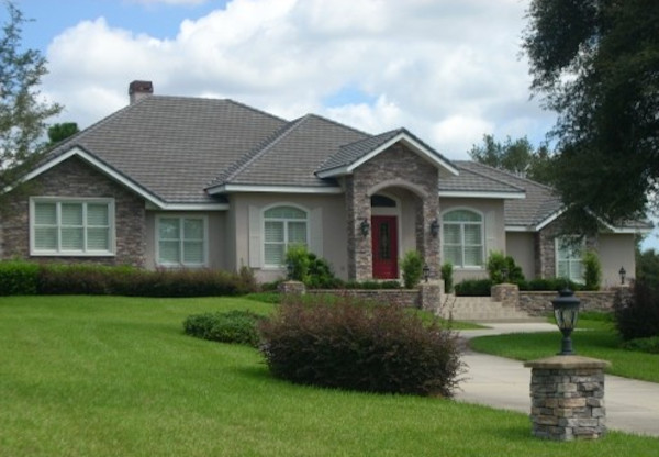 This is an example of a beige traditional brick house exterior in Tampa with three floors.