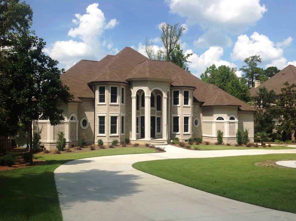 This is an example of an expansive and white mediterranean two floor brick detached house in Charlotte with a hip roof and a shingle roof.