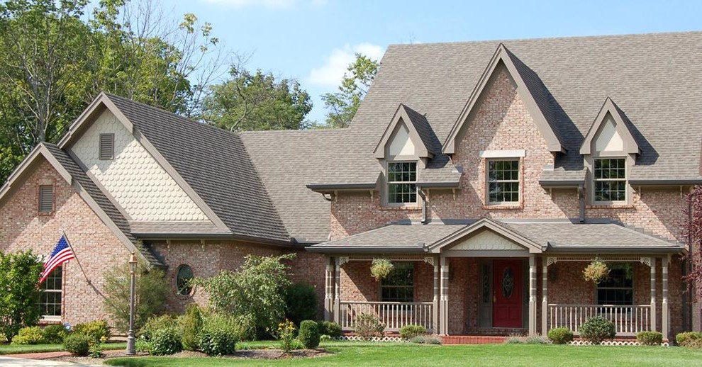 На фото: двухэтажный, кирпичный, красный дом среднего размера в классическом стиле с двускатной крышей с