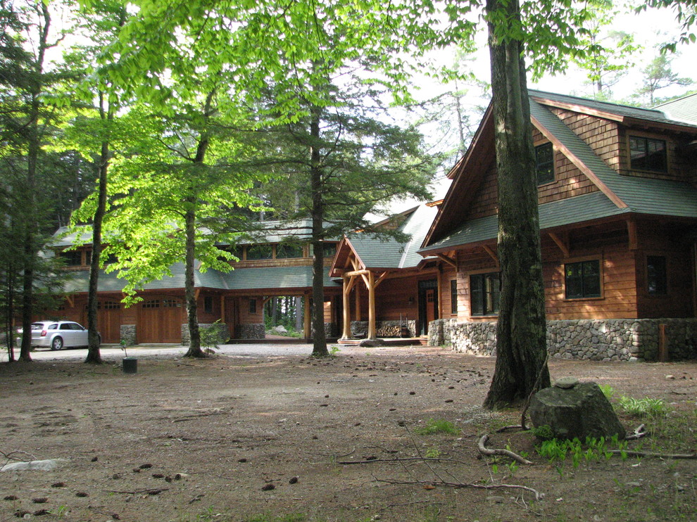 Inspiration för ett stort rustikt brunt trähus, med två våningar och pulpettak