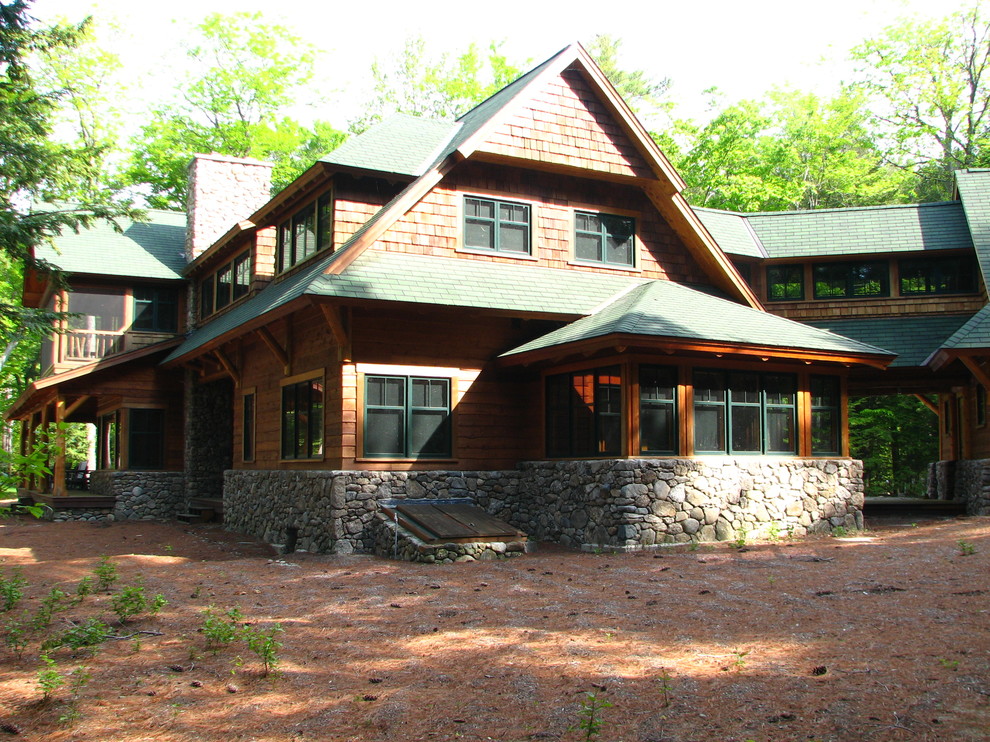 Esempio della casa con tetto a falda unica grande marrone rustico a due piani con rivestimento in legno
