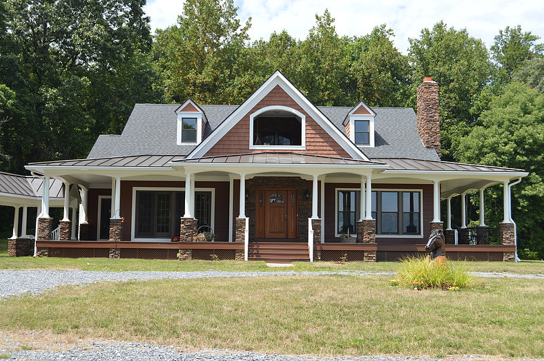 Idée de décoration pour une façade de maison marron champêtre en bois de taille moyenne et à un étage avec un toit à quatre pans et un toit mixte.