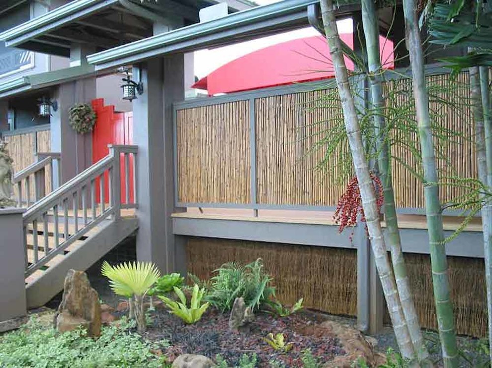 Medium sized and brown world-inspired two floor house exterior in Hawaii with wood cladding.