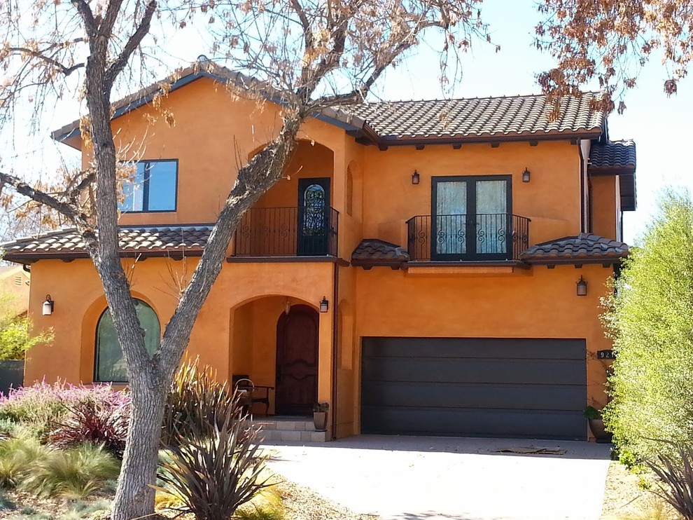 ロサンゼルスにある高級な中くらいな地中海スタイルのおしゃれな家の外観 (漆喰サイディング、オレンジの外壁) の写真