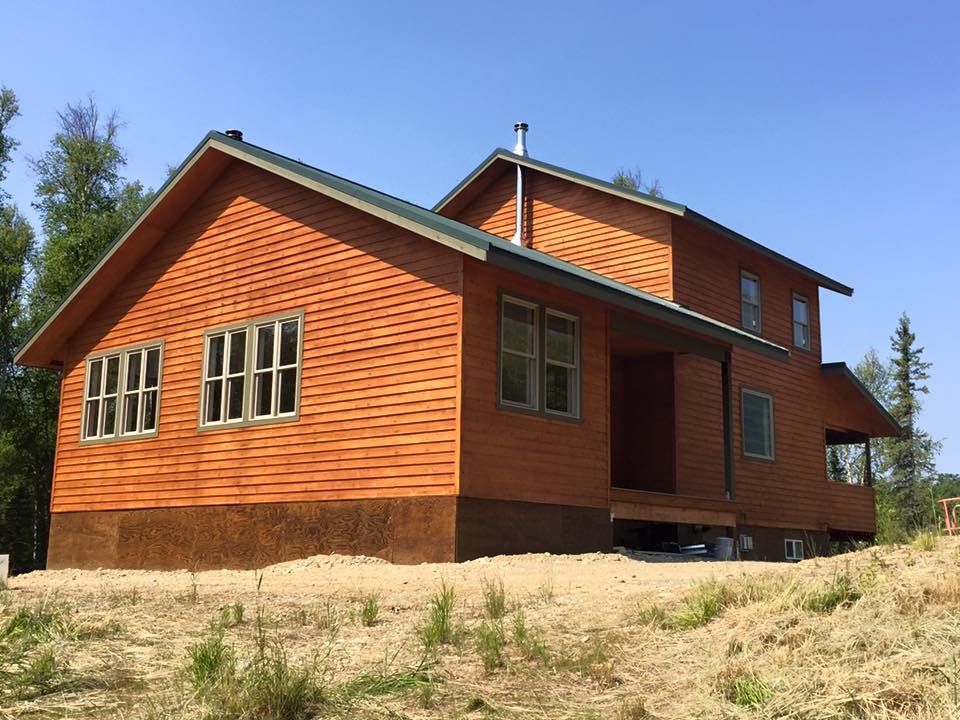 Foto de fachada de casa marrón rústica grande de dos plantas con revestimiento de madera, tejado a dos aguas y tejado de teja de madera