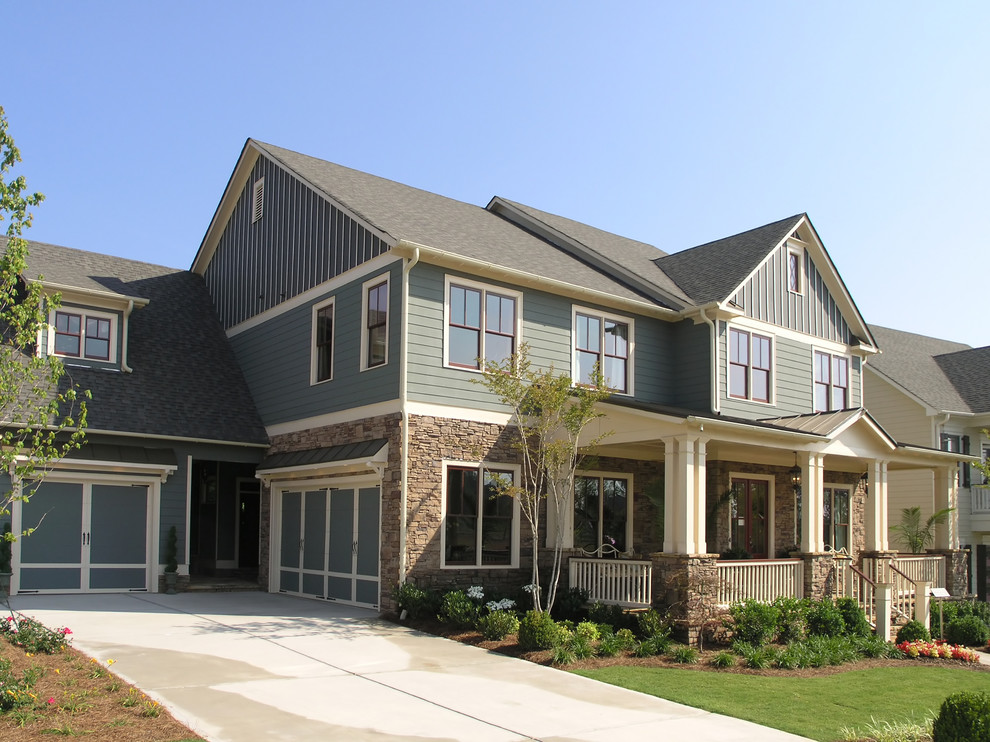 Exemple d'une grande façade de maison verte chic à un étage avec un revêtement en vinyle et un toit à croupette.