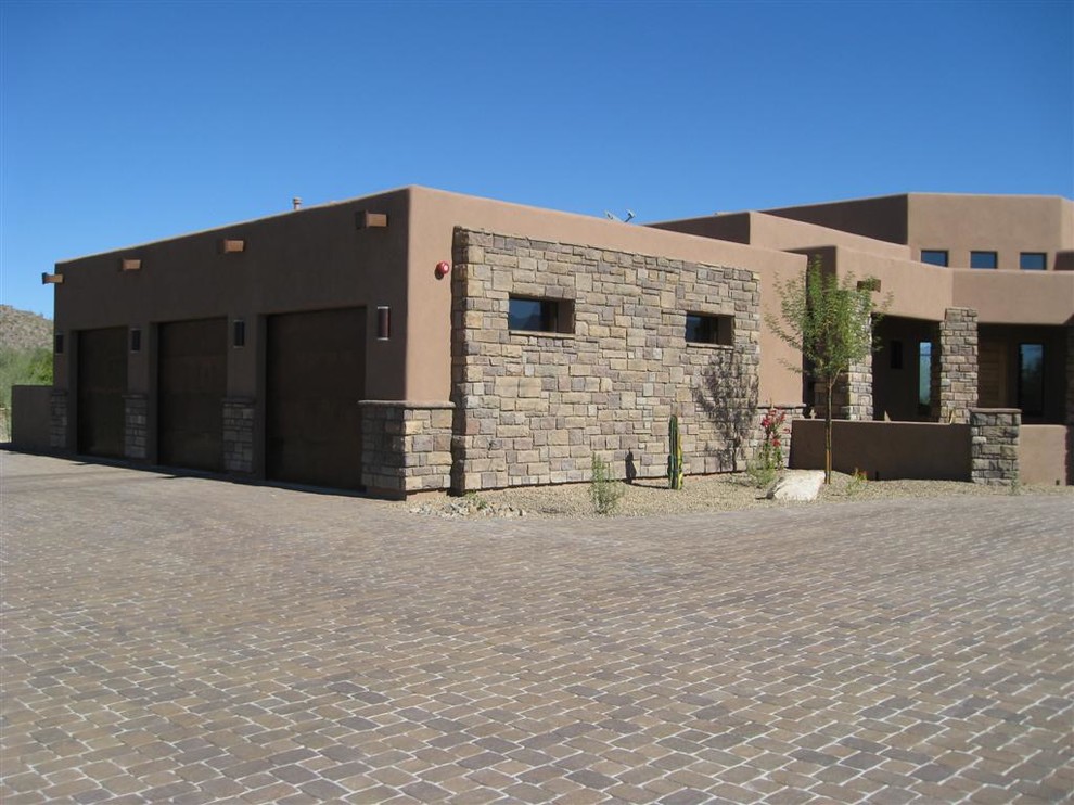 На фото: большой, двухэтажный, коричневый частный загородный дом в стиле фьюжн с облицовкой из цементной штукатурки, плоской крышей и зеленой крышей