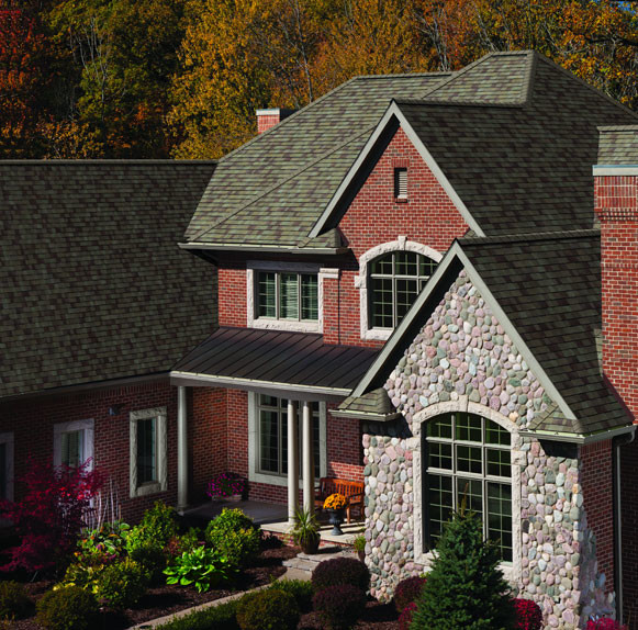 Cette photo montre une grande façade de maison rouge craftsman en brique à un étage avec un toit à croupette.
