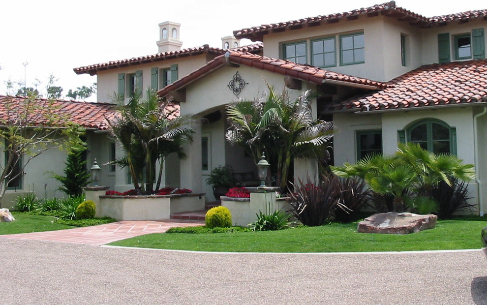 Ejemplo de fachada de casa blanca de estilo americano grande de dos plantas con revestimiento de estuco, tejado a cuatro aguas y tejado de teja de barro