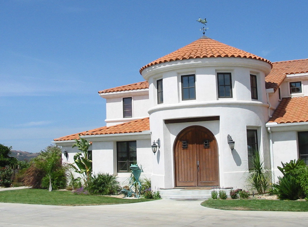 Modelo de fachada de casa blanca mediterránea grande de dos plantas con revestimiento de estuco, tejado a cuatro aguas y tejado de teja de barro