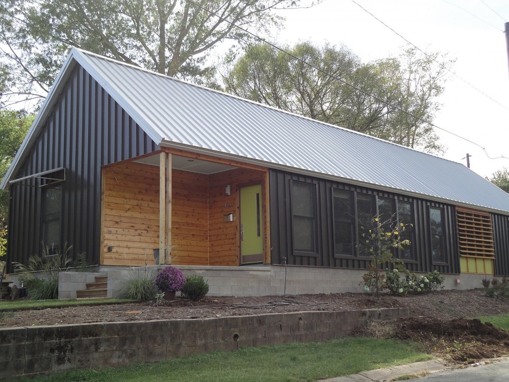 Immagine della facciata di una casa piccola marrone eclettica a un piano con rivestimento in metallo e tetto a capanna