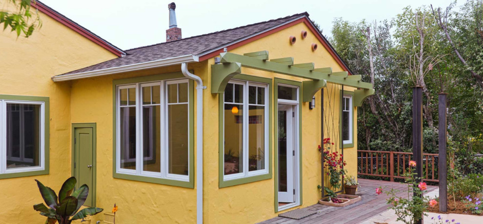 На фото: одноэтажный, желтый частный загородный дом среднего размера с облицовкой из цементной штукатурки, двускатной крышей и крышей из гибкой черепицы