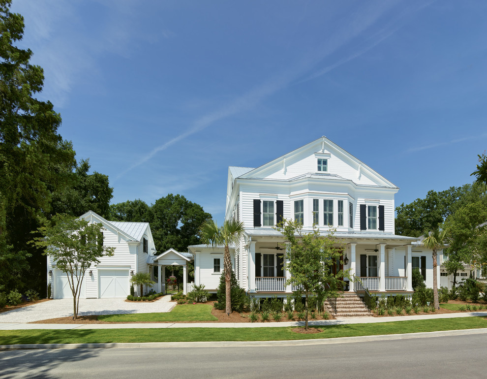 Foto de fachada de casa blanca marinera de dos plantas con tejado a dos aguas y tejado de metal