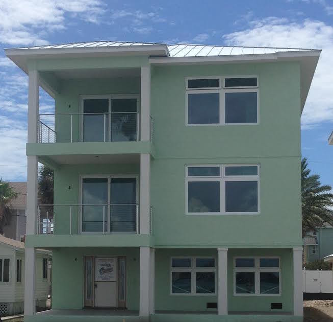 Diseño de fachada de casa verde marinera de tamaño medio de tres plantas con revestimiento de estuco, tejado a dos aguas y tejado de metal