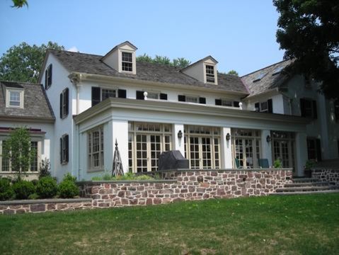 Esempio della facciata di una casa grande bianca classica a due piani con rivestimento in stucco