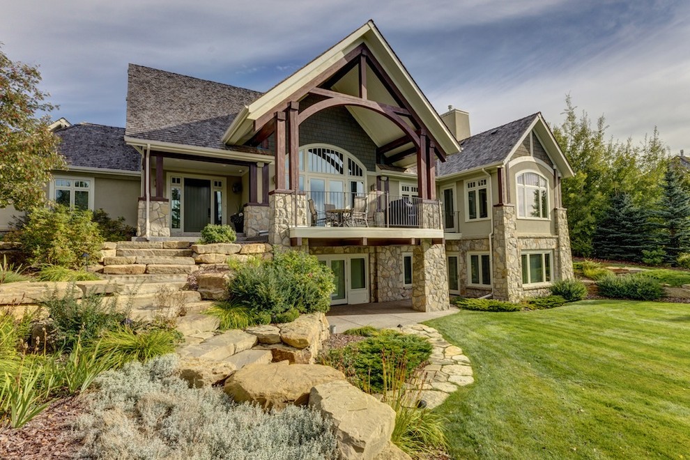 Traditional two-storey beige exterior in Calgary with stone veneer.
