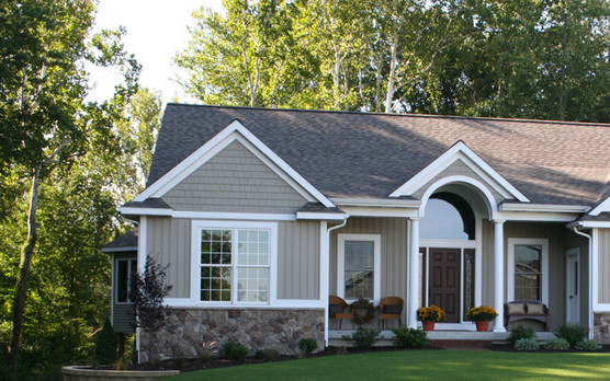 This is an example of a medium sized and gey traditional bungalow house exterior in Grand Rapids with mixed cladding.
