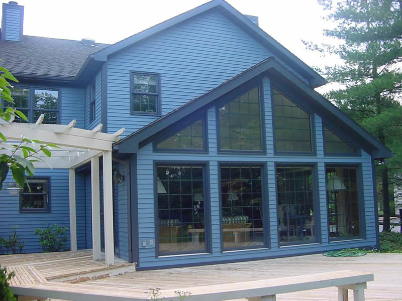 Esempio della facciata di una casa grande blu classica a due piani con rivestimento in legno