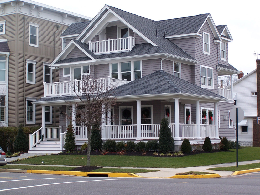 Large elegant gray three-story wood house exterior photo in Other with a hip roof and a shingle roof