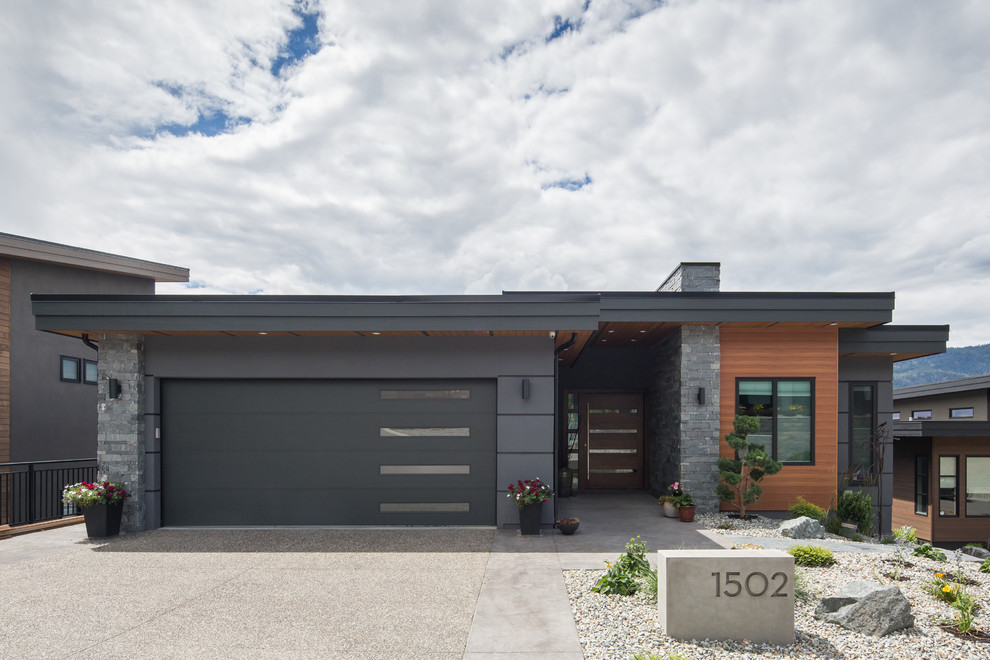 Imagen de fachada de casa gris contemporánea de una planta con revestimientos combinados y tejado plano