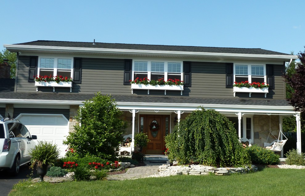 Exemple d'une façade de maison beige chic de taille moyenne et à un étage avec un revêtement en vinyle et un toit à deux pans.