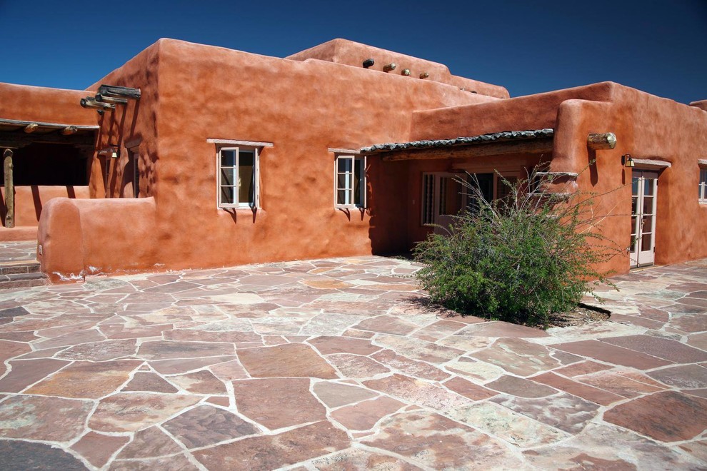 Imagen de fachada marrón de estilo americano de tamaño medio de una planta con revestimiento de adobe y tejado plano