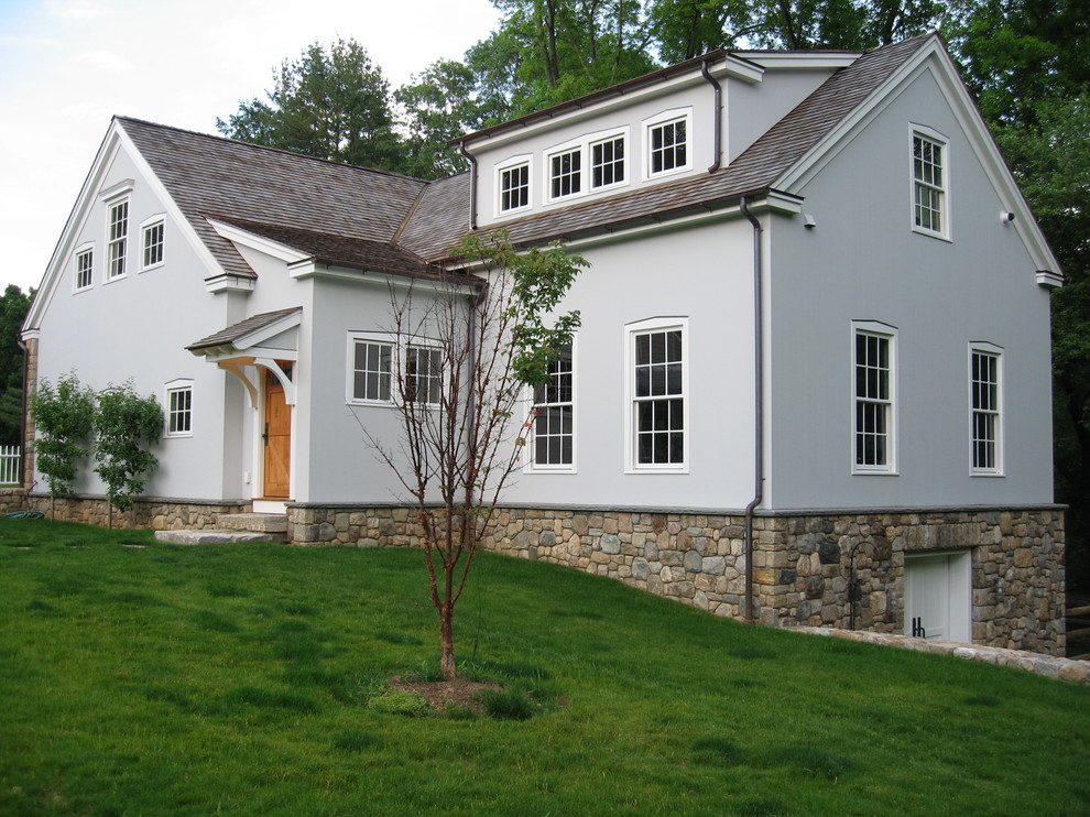 Esempio della facciata di una casa blu country a due piani di medie dimensioni con rivestimento in stucco e tetto a capanna