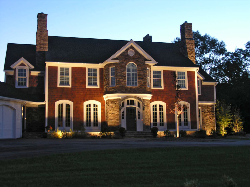 Foto della facciata di una casa rossa classica a due piani con rivestimenti misti