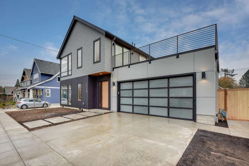 Cette image montre une façade de maison grise minimaliste de taille moyenne et à un étage avec un revêtement mixte et un toit à deux pans.