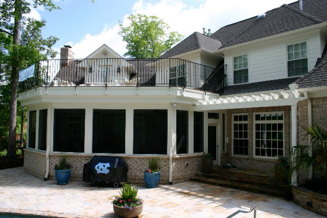 Example of a large classic white two-story brick flat roof design in Raleigh