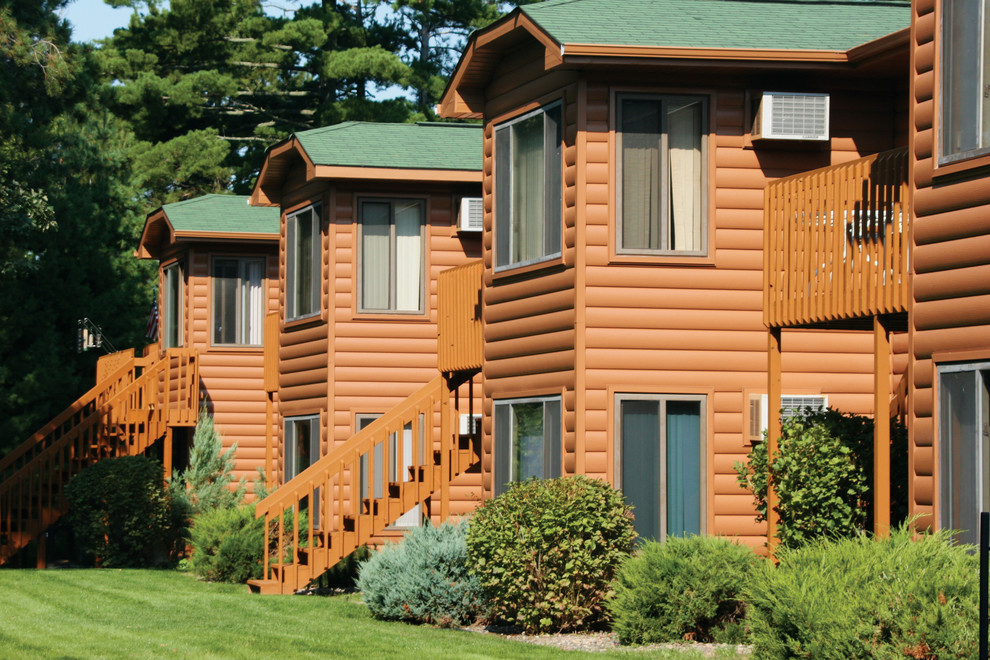 Стильный дизайн: коричневый дом в стиле рустика с облицовкой из металла - последний тренд
