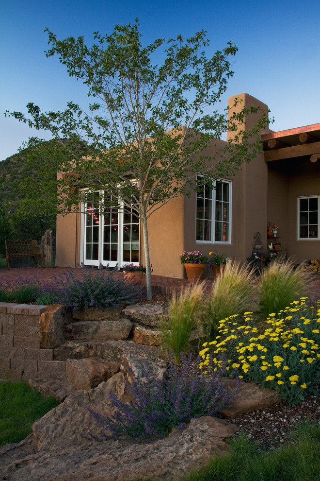 Mittelgroßes, Einstöckiges Klassisches Haus mit Lehmfassade, brauner Fassadenfarbe und Flachdach in Albuquerque