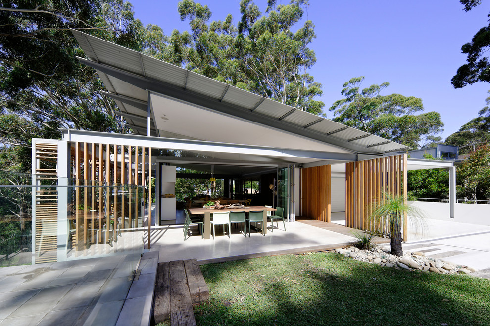 This is an example of a medium sized and brown contemporary two floor detached house in Sydney with wood cladding, a flat roof and a metal roof.