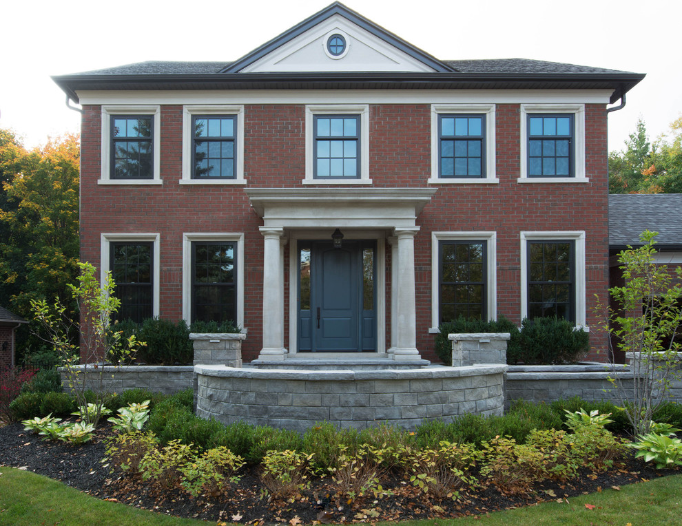 Inspiration for a large and red traditional brick detached house in Toronto with three floors.