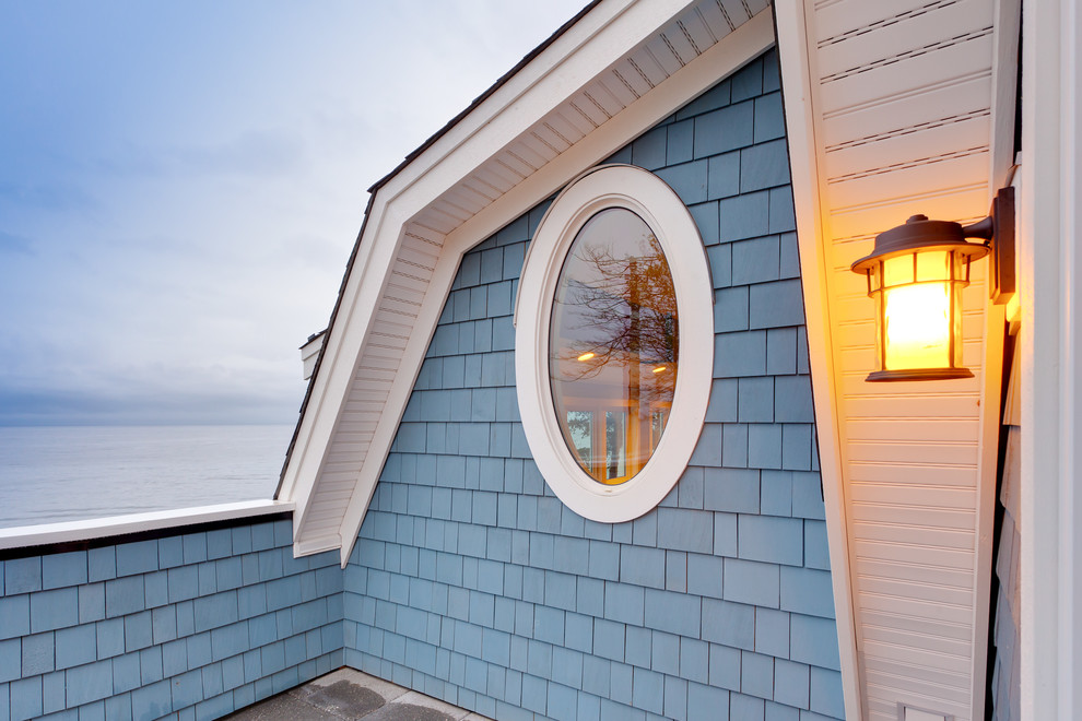 Exemple d'une façade de maison bleue bord de mer.