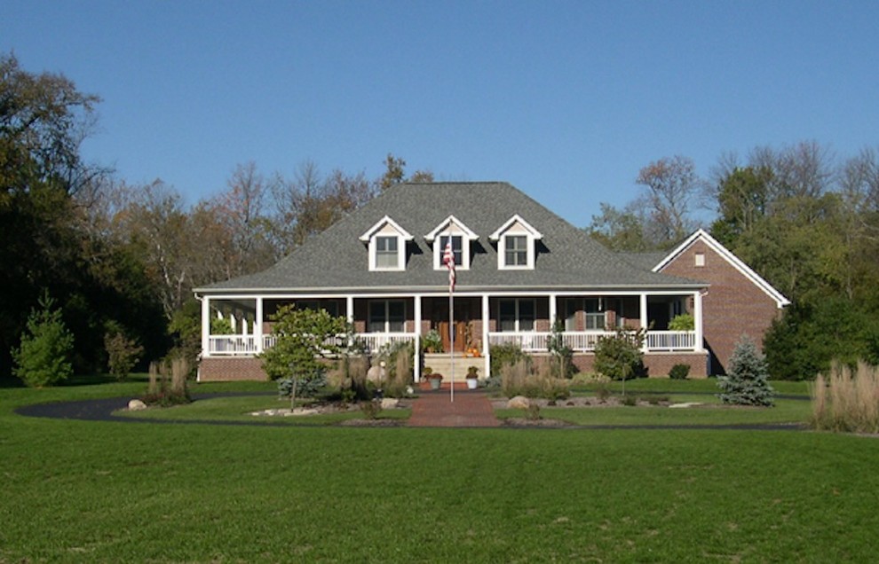 Esempio della villa grande rossa american style a due piani con rivestimento in mattoni, tetto a padiglione e copertura a scandole