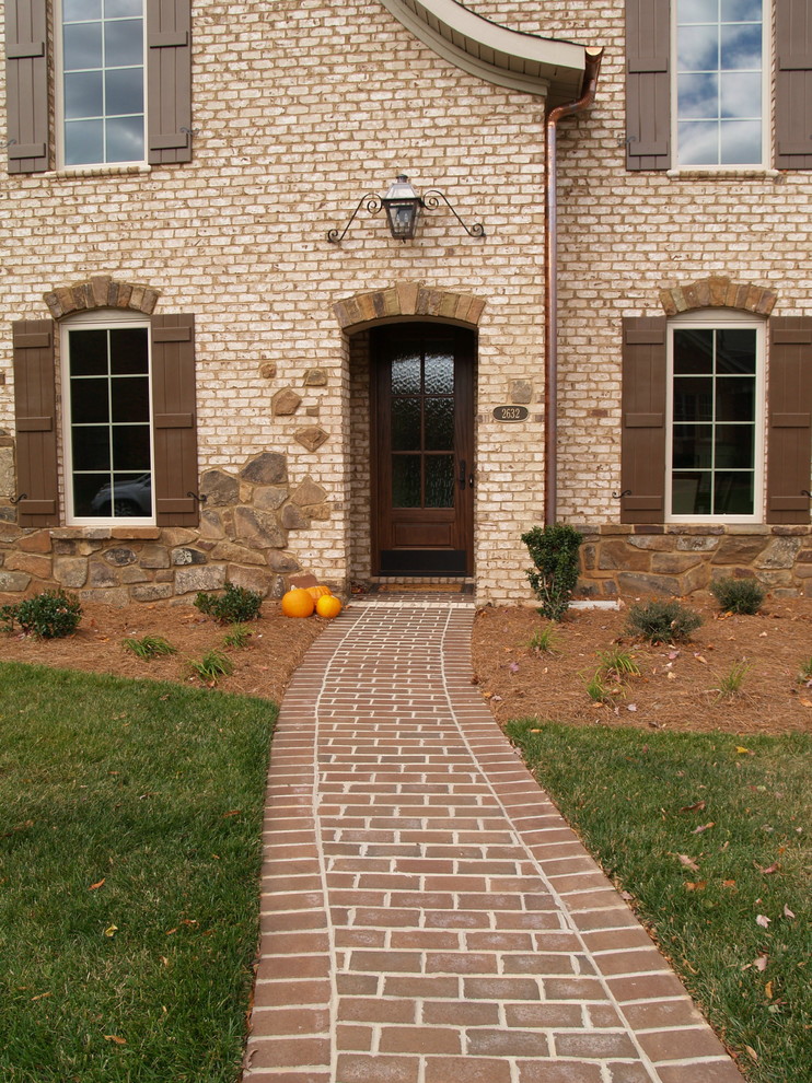 Transitional white brick exterior home photo in Other