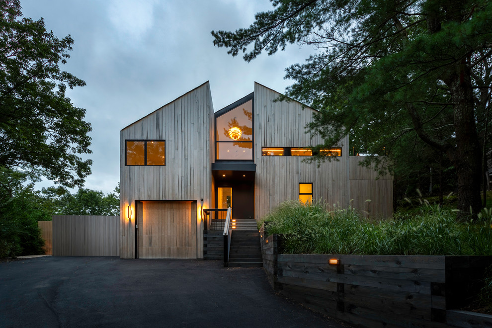 Diseño de fachada de casa contemporánea de tamaño medio a niveles con revestimiento de madera, tejado a dos aguas y tejado de teja de madera